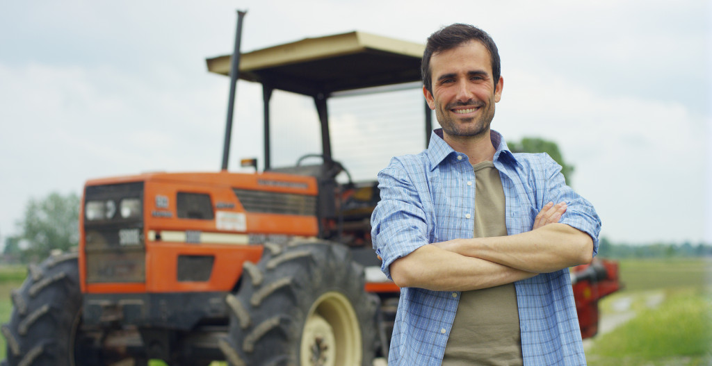 a man standing in front of a compact tractor for landscaping