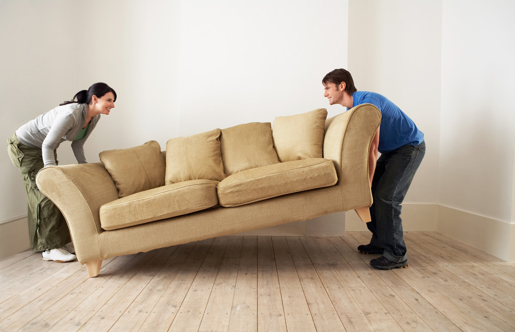 A couple moving a large sofa