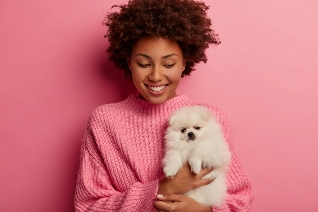 woman in pink carrying her dog pet