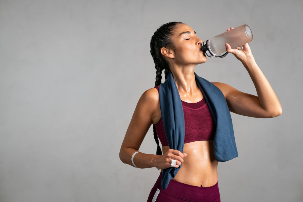 A fit woman drinking water